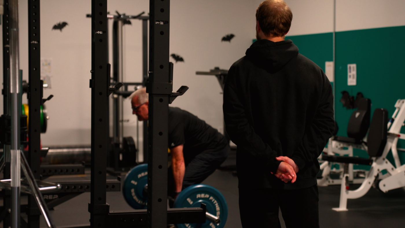 Shapesmith watching an Adventurer's deadlift form