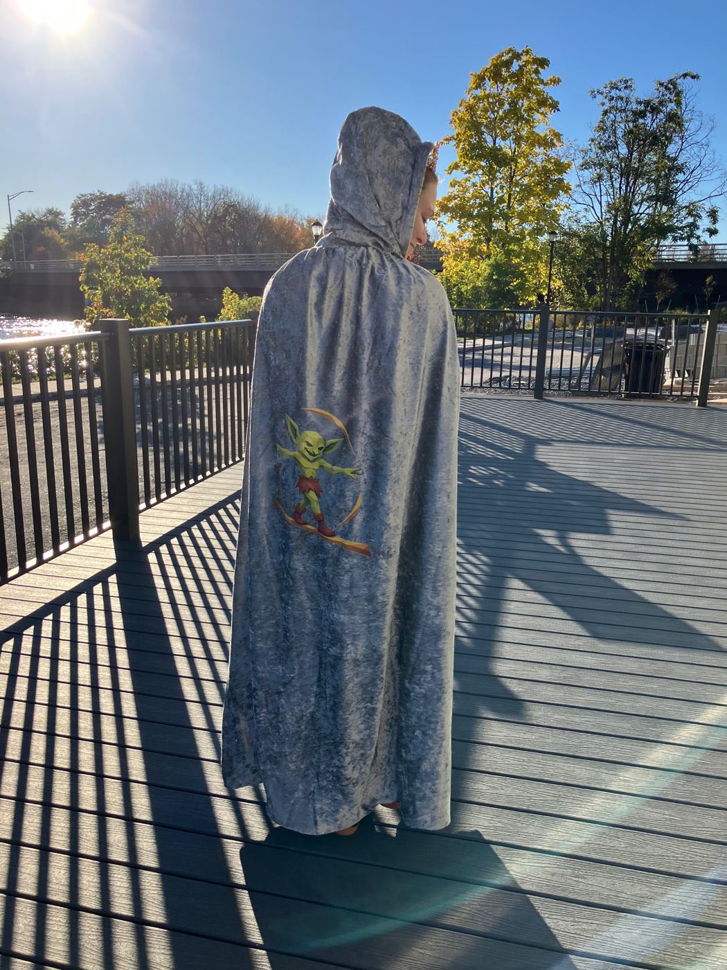 A prize cloak with goblin artwork, worn on the riverside deck