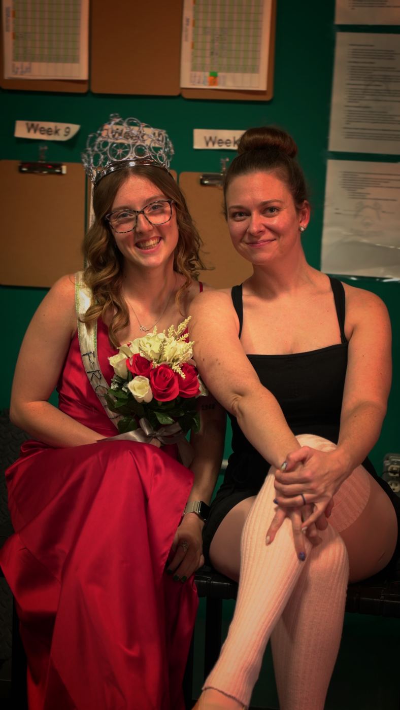 An Adventurer crowned in a red gown with a friend