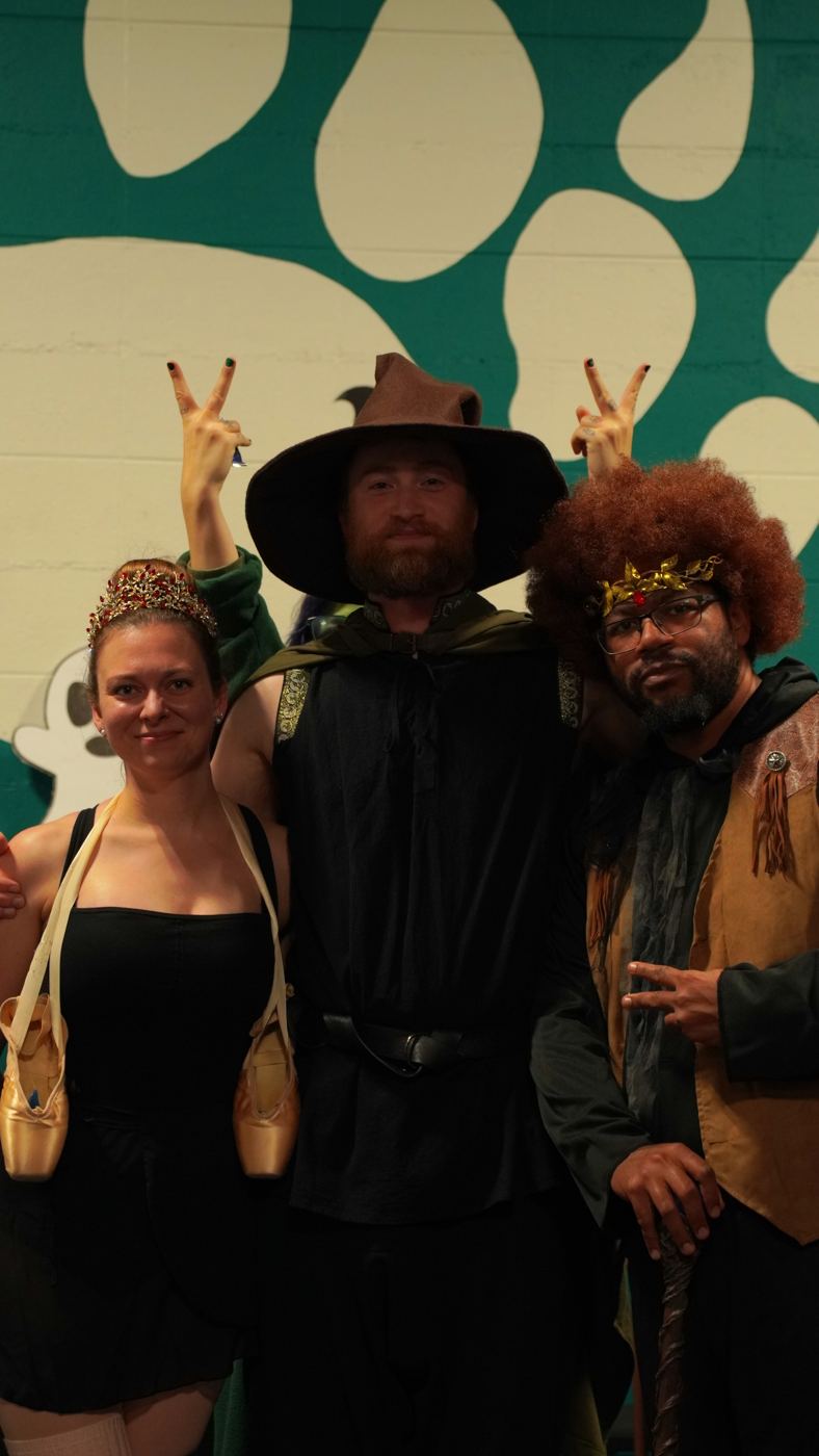 Halloween winners: a ballerina, a wizard and a king in front of the bear-paw mural