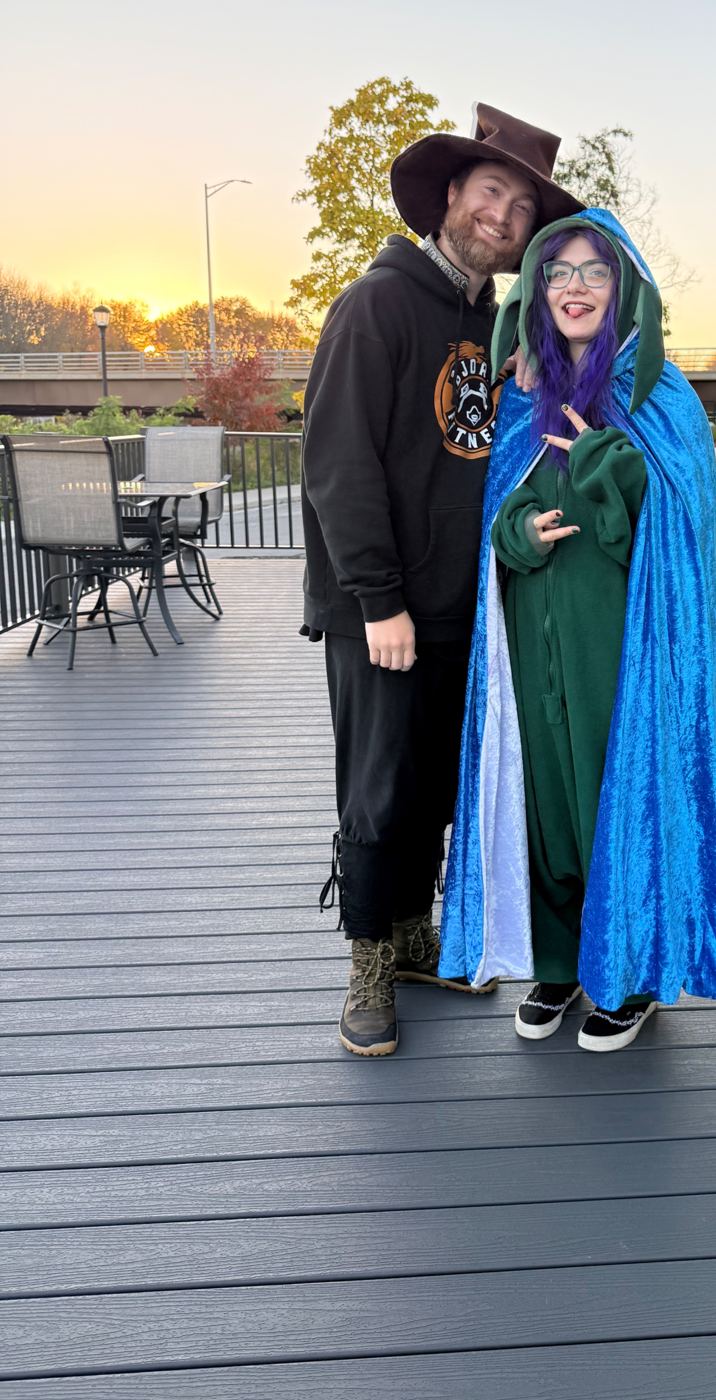 Alexander in a wizard hat with an Adventurer in a blue cloak at sunset